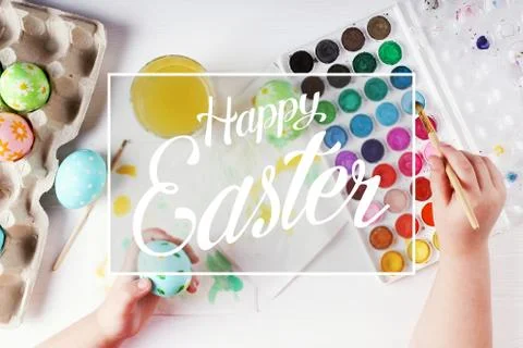Kid hand painted boiled Easter eggs, paints and brushes on a white table. Pre Stock Photos