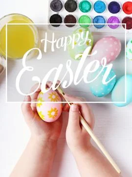 Kid hand painted boiled Easter eggs, paints and brushes on a white table. Pre Stock Photos