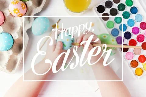 Kid hand painted boiled Easter eggs, paints and brushes on a white table. Pre Stock Photos