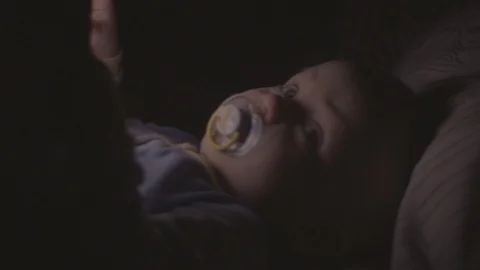 Kid hand touching screen of touch pad while playing video games in his bed Video stock 86637069