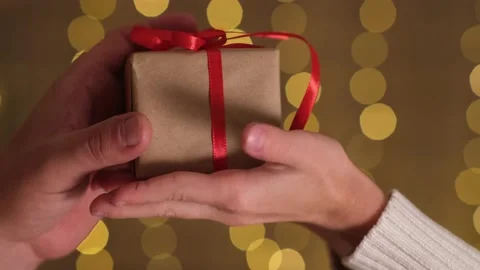 Kid hands giving Christmas small gift box with red bow to adult Video stock 220263672