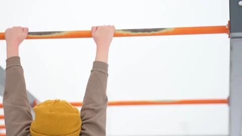 Kid hanging by the hands from orange bars Video stock 275877182
