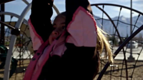 Kid hanging from monkey bars HD Stock Footage 32383259