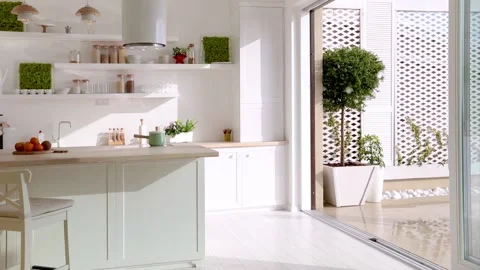 Kid has fun under the rain. open space kitchen with sliding door and patio Stock Footage 161596543