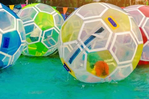 Kid having fun in giant bubble ball on water in the swimming pool at the them Stock Photos
