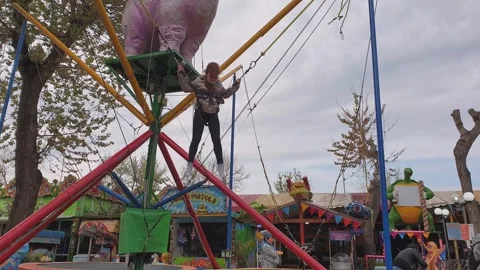 Kid having fun jumping on trampoline on cloudy day Video stock 280894981