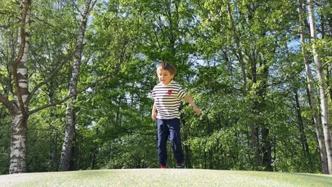A kid is having fun jumping on trampoline in the park. Happy toddler childhood. Stock Footage 313954909