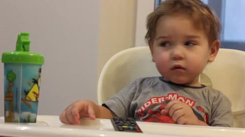 Kid is having fun sitting in his chair in the kitchen at home Video stock 123066036