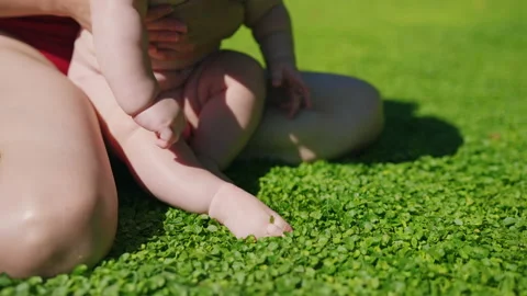 A kid having loads of fun jumping in grass. Clouse up portrait of toddlers bare Stock Footage 181409930