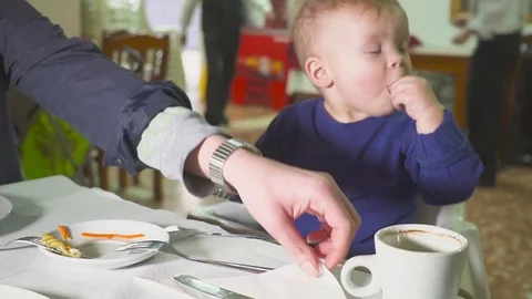 The kid is having lunch at the restaurant. In the hands of a spoon and fork Video stock 84790338