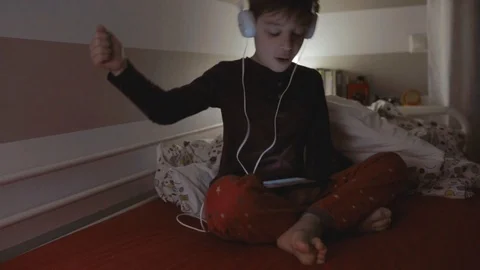 Kid with headphones dancing while looking at the tablet Stock Footage 89757047