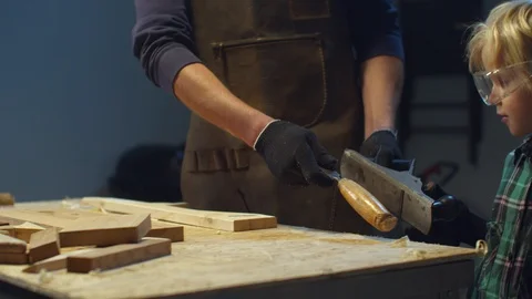 Kid helps dad to remove tools from the workbench Stock Footage 128184932