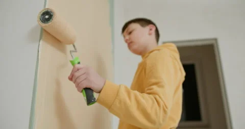 Kid helps parents to paint wall. Repair of a new house. Child boy painted the Stock Footage 273202095