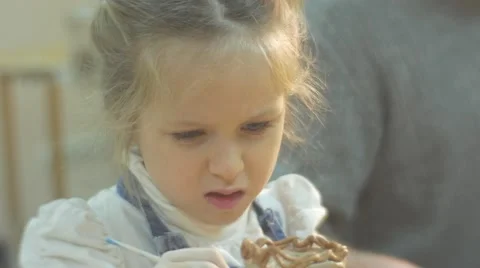 Kid With Her Face Bored is Glazing a Clay Figurine Little Girl is Painting a Stock Footage 59129632