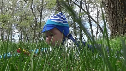 The kid hiding in the grass Stock Footage 76727865