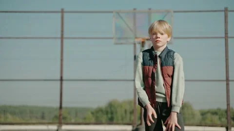 Kid hitting a basketball ball, practicing on a court in the park Video stock 166835233