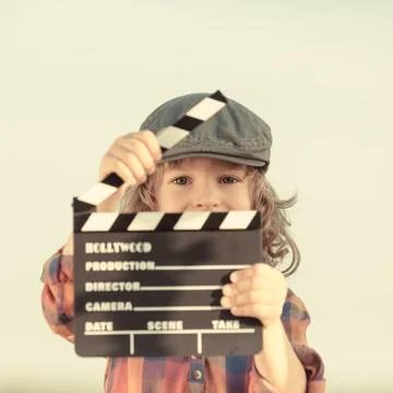 Kid holding clapper board in hands Stock Photos