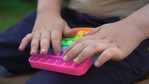 Kid Holding Rainbow Pop It Fidget Toy in Hands. 07-01-21 Stock Footage 159073944