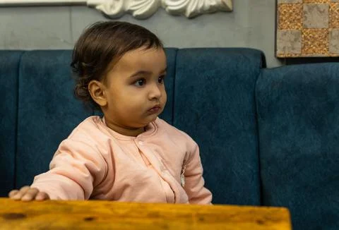 Kid innocent face expression sitting at sofa at night Foto stock