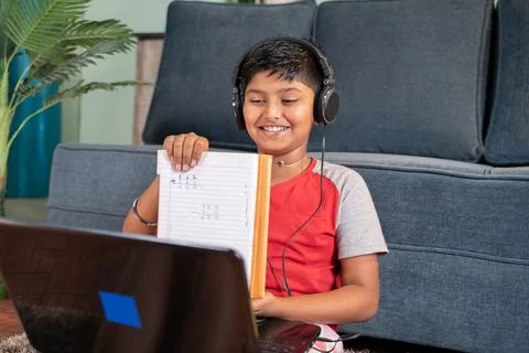 Kid interacting during online class by showing solved problems to tutor on la Stock Photos