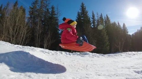 Kid jump in slow motion while sledding down in winter sunny day in Zakopane. Stock Footage 152451543
