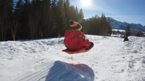 Kid jump in slow motion while sledding down in winter sunny day in Zakopane. Stock Footage 152451544