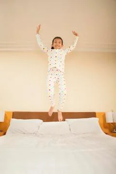 Kid Jumping on Bed Stock Photos