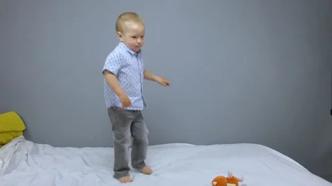 Kid jumping on gray background Stock Footage 132663848