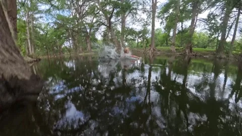 Kid jumping into river from rope swing Video stock 313757126