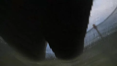 The kid is jumping on a trampoline mat on a blue skay background, low-angle shot Stock-Footage 283118438