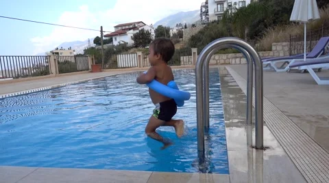 Kid jumps into water and his safety ring opens Stock Footage