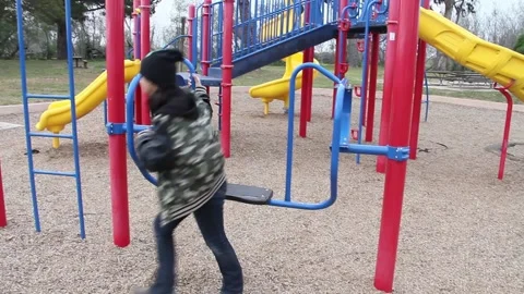 Kid jumps on weird looking swing Stock Footage 155491272