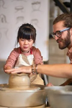Kid learning how to mold clay pot with hands on Pottery workshop.  Creative.. Stock Photos