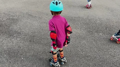 Kid Learning Roller Skating With Helmet Elbow Pads and Knee Protection at day Vídeo Stock 347128338