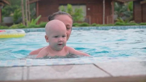 Kid learning to swim. Mom is engaged in the pool with a child 스톡 동영상 195295760