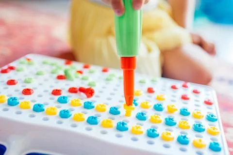 Kid learning to use screwdriver. Multicolor screws. Future occupation concept Stock Photos