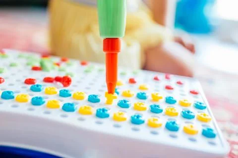 Kid learning to use screwdriver. Multicolor screws. Future occupation and early Stock Photos