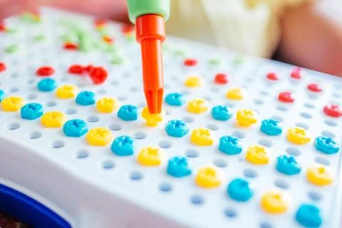 Kid learning to use screwdriver. Multicolor screws. Future occupation and early Stock Photos