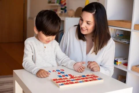 Kid learning to write and read with a alphabet and mother or teacher help. Ho Stock Photos