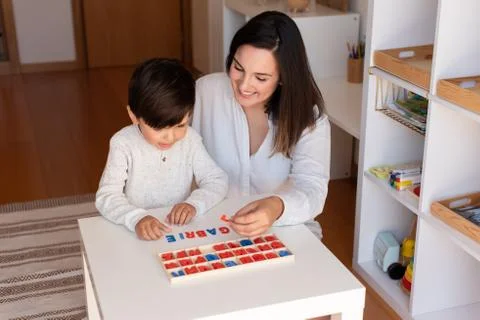 Kid learning to write and read with a alphabet and mother or teacher help. Ho Stock Photos