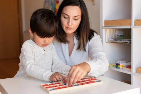 Kid learning to write and read with a alphabet and mother or teacher help. Ho Stock Photos