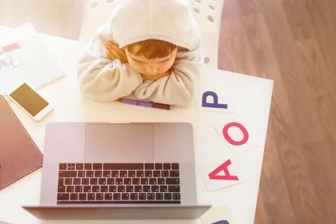 Kid learns at the computer on-line. Child boy learning letters and alphabet at Stock Photos