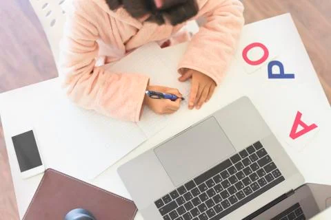 Kid learns at the computer on-line. Child girl learning at home. Home Educati Foto stock