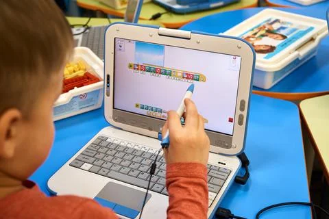Kid learns how to code. Little boy working on laptop at school Stockfoto's