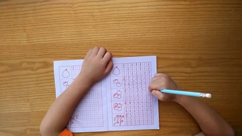 Kid learns to write Arabic numerals by following guides Stock Footage 80362032