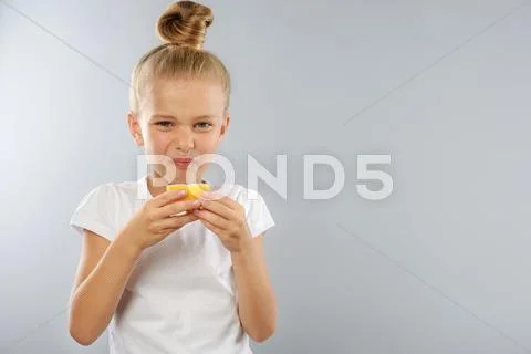 Kid with lemon on grey background and copy space Stock Photos