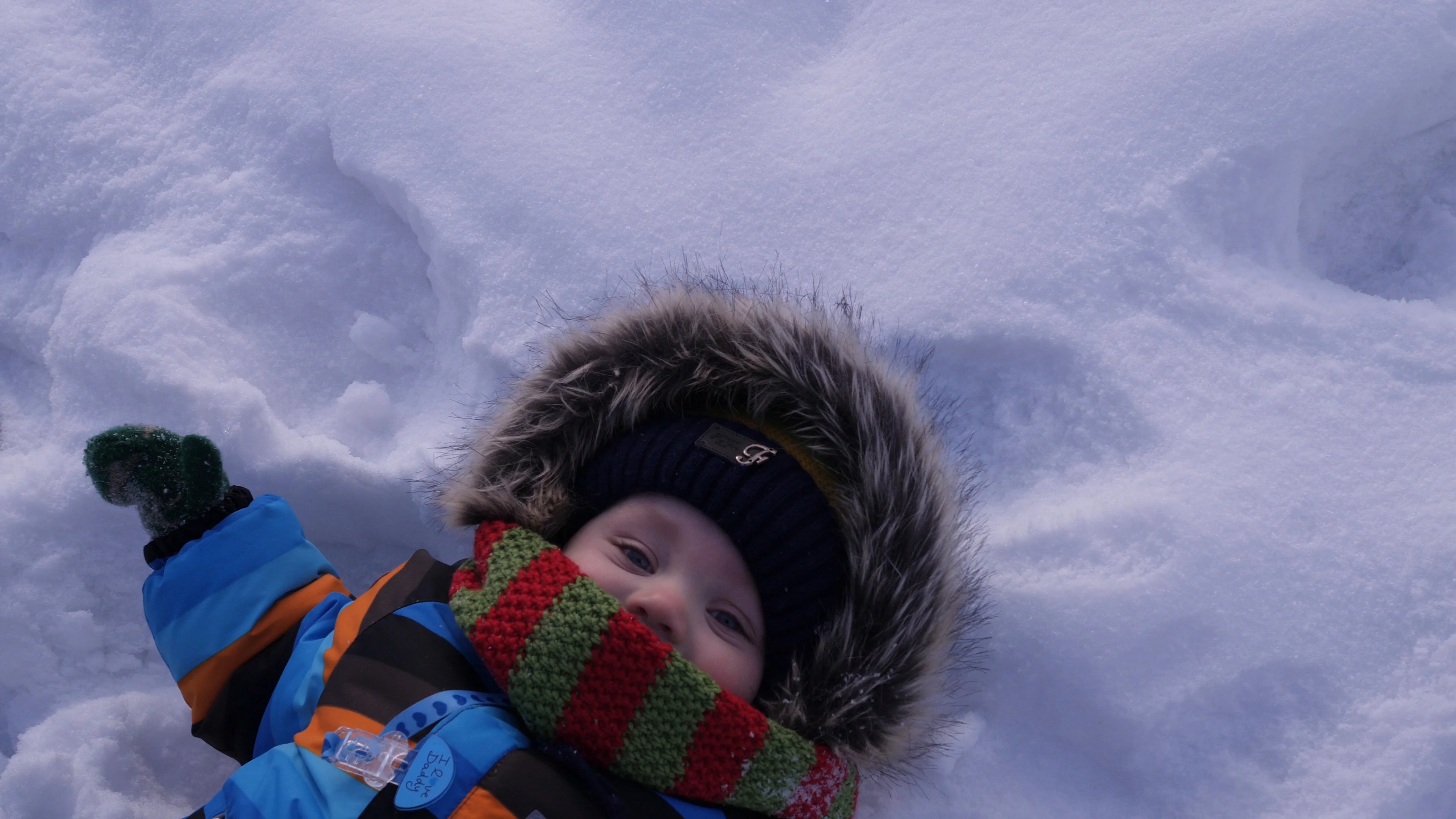 The kid lies in the snow. Making a Snow Angel