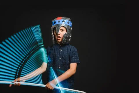 A kid with a light saber in his hands play in a superhero battle. Stock Photos