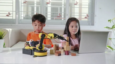 Kid little girl program code to robot with laptop computer and the boy test with Stock Footage 208822126