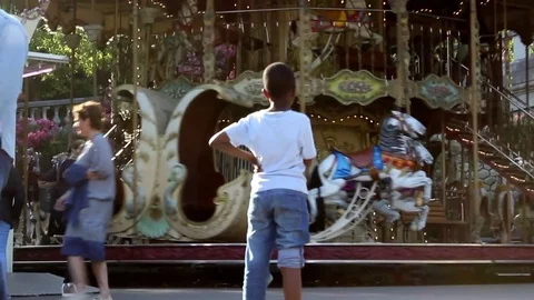 Kid looking at merry go round Stock Footage 78340862